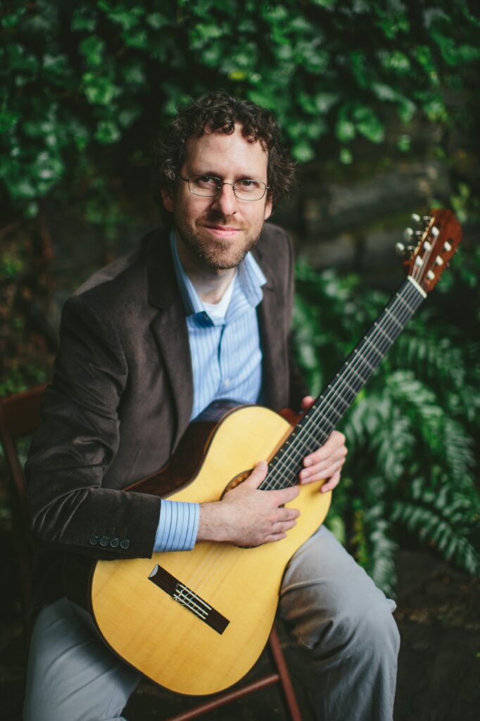Portrait of Adam Frank with guitar